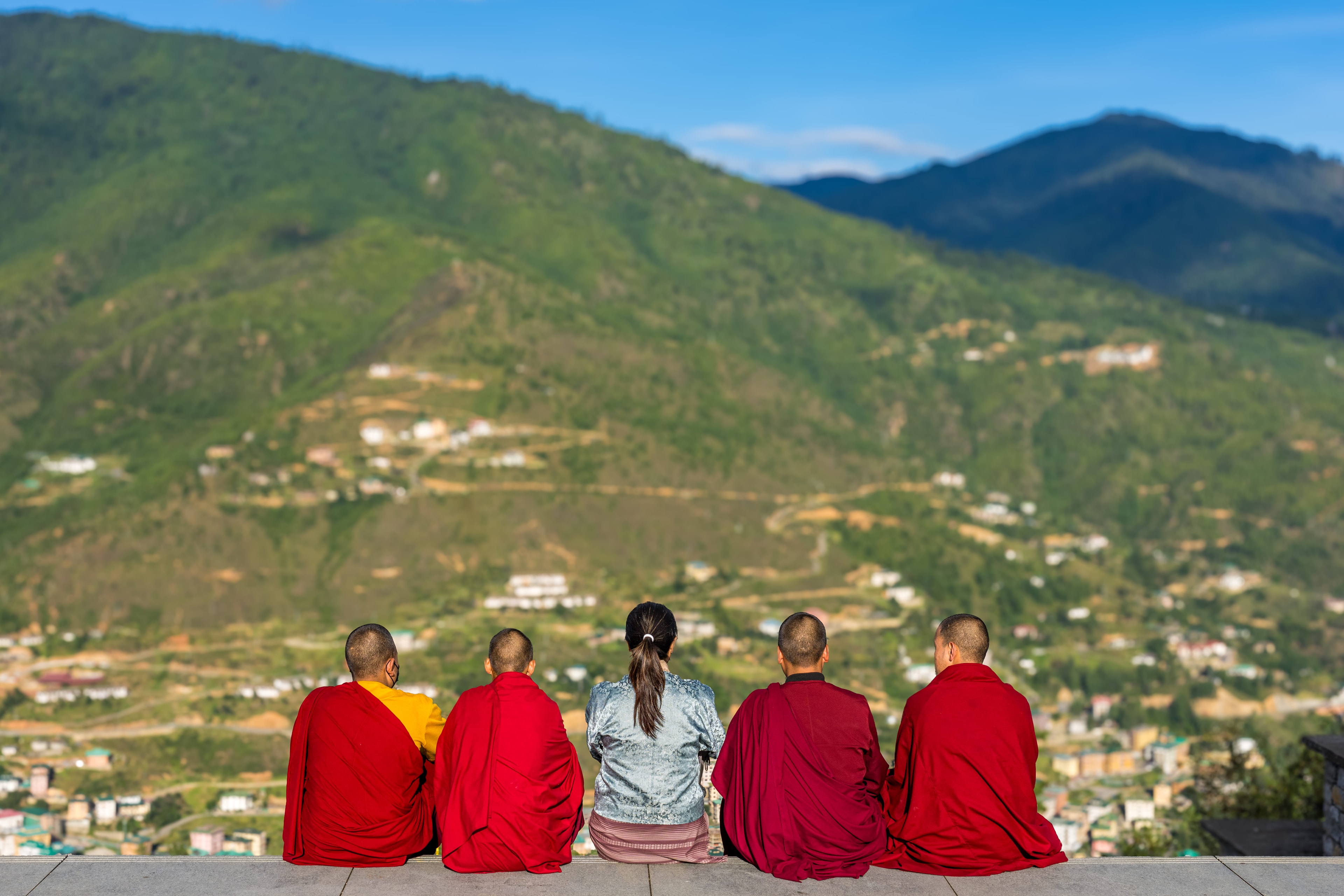 Monks overlooking a Himalayan valley in Bhutan, curated private travel by Druk International Tours